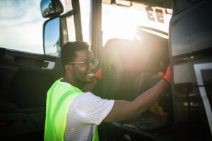 young driver gets into his lorry smiling